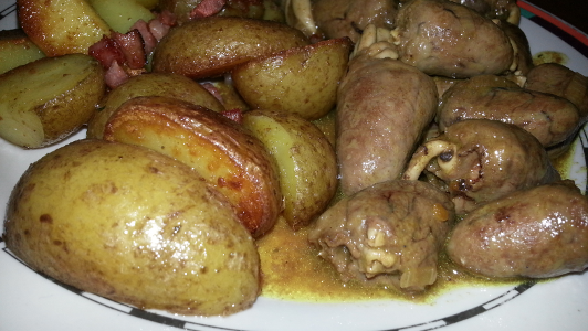 Nahaufnahme: Hühnerherzchen in Currysauce mit Röstkartoffeln